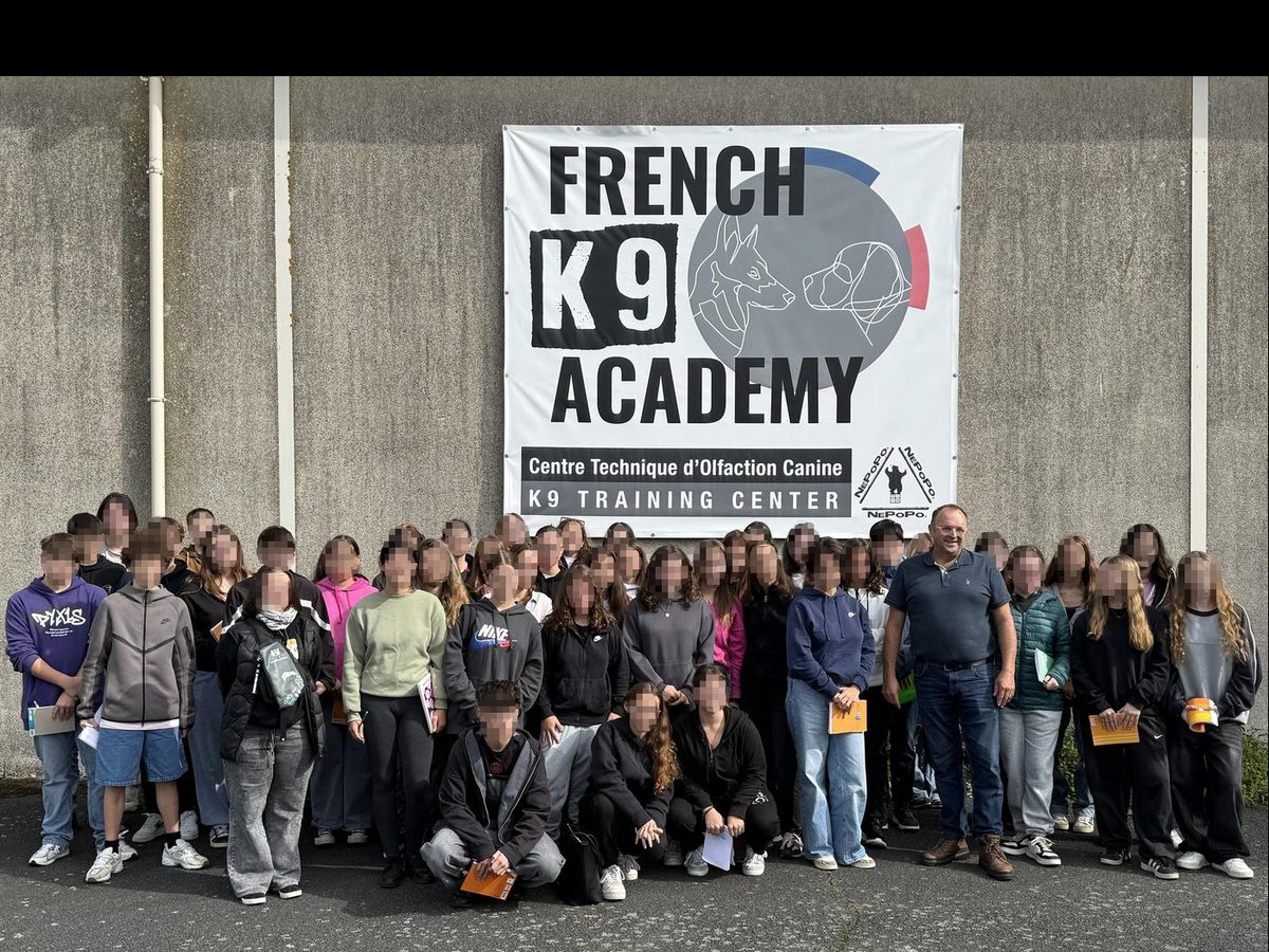 Groupe de stagiaires accueillis au centre, devant la bannière French K9 Academy